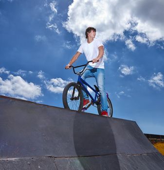 Practicing for the x games. a teenage boy riding a bmx at a skatepark.