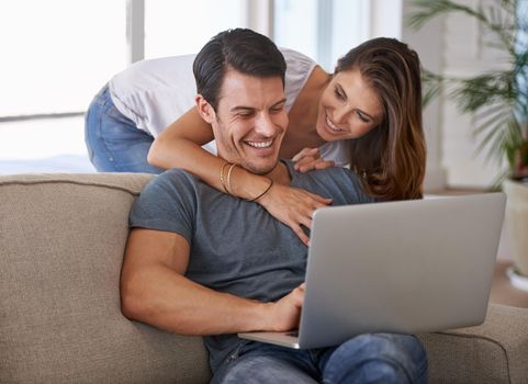 You make me feel so happy. An affectionate young couple using a laptop in their home.