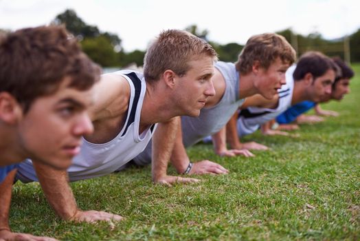 Hardcore strength training. a group of young sportsmen training outdoors.