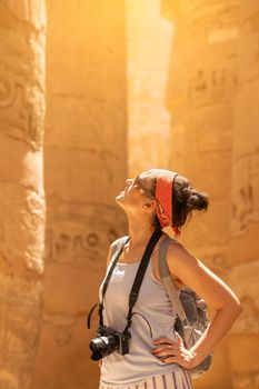 Tourist looking up to columns with hieroglyphs in a temple