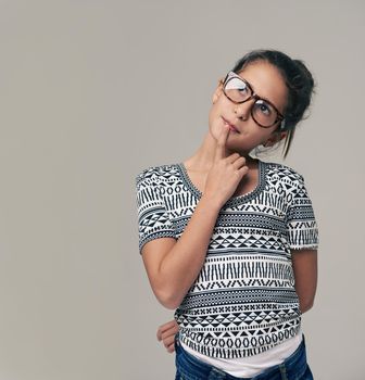 Bi-spectacled fun. Studio shot of a young girl with glasses against a gray background.