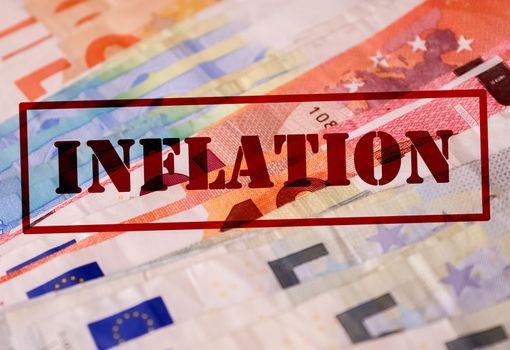 A stamp with the red lettering Inflation on numerous euro banknotes - Financial crisis concept in Germany and Europe.