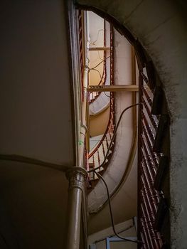 Looking up to Spiral staircase with metal and wooden railings