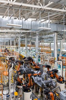 Vertical photo of automobile production line. Modern car assembly plant. Auto industry. Interior of a high-tech factory, modern production