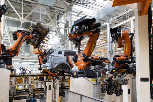 Photo of automobile production line. Modern car assembly plant. Auto industry. Interior of a high-tech factory, modern production