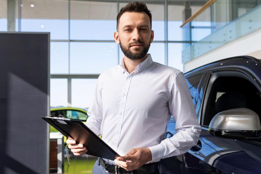 manager in a car dealership prepares papers for buying a new car