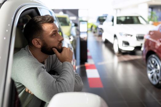 a man in a car dealership dreaming about buying a new car
