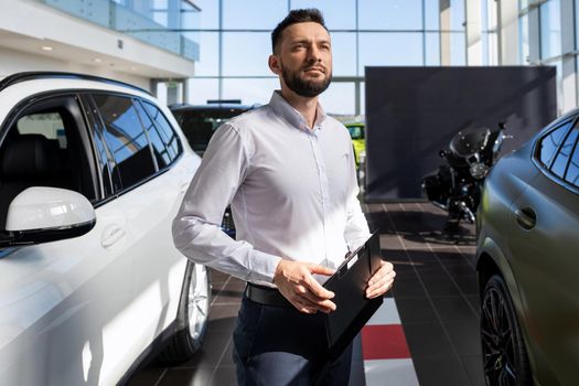confident businessman filling out paperwork for buying a new car at a car dealership