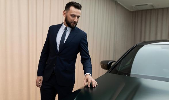 successful entrepreneur in business suit examining sports car in premium showroom