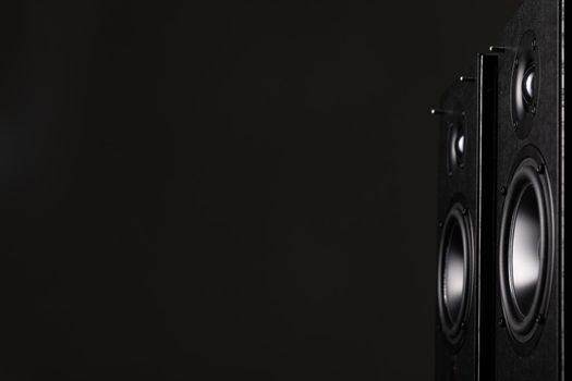 two large black speakers with large speakers on a black background with copy-space