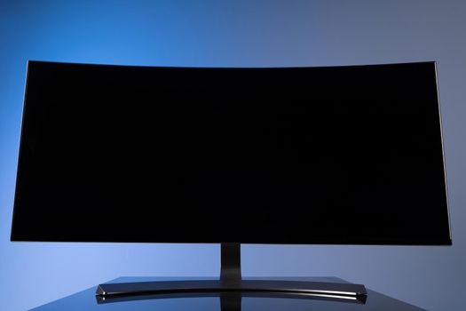 huge widescreen curved monitor with copy-space space on gray-blue background close-up