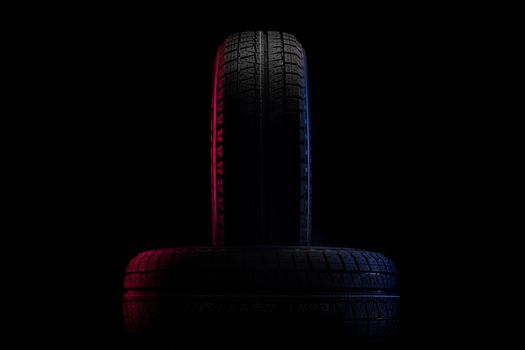 tires with a tread for winter driving on a black background with an image of red-blue illumination