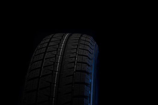 new rubber tire on a black background close-up