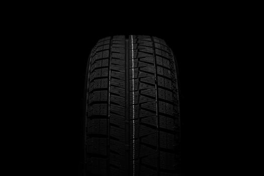 tire for safe driving on snow ice on a black background close-up