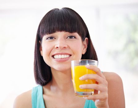 Getting in my daily dose of vitamin C. A young woman drinking orange juice.