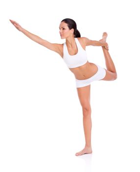 Balanced perfection. Full length studio shot of a young in exercise clothing balancing on one leg isolated on white.