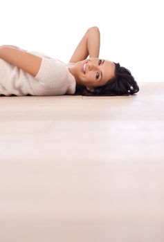 Feeling relaxed on the floor. A young woman smiling at the camera as she lies on the floor.