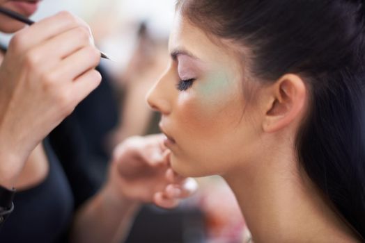 Adding the finishing touches. A young woman having makeup applied.