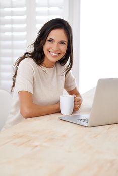 Enjoying the internet and all its freedom. Portrait of an attractive young woman using her laptop at home.