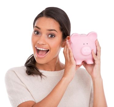 My savings are through the roof. Portrait of an attractive young woman holding a piggybank and looking excited.