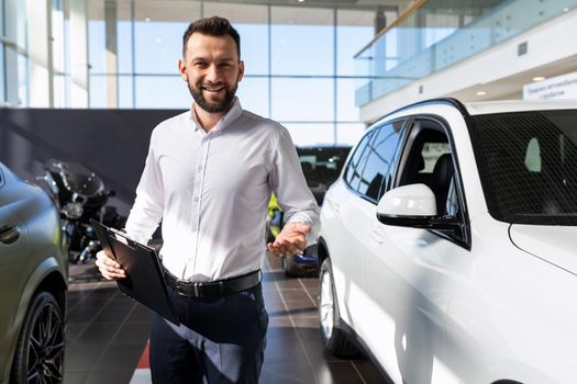 car dealership manager greets the buyer with a smile