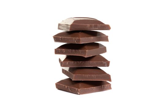 milk chocolate slices stacked pyramid on top of each other on white isolated background