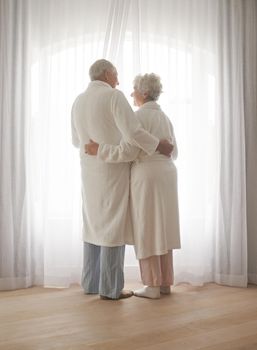 Facing the final curtain together. Full-length shot of an elderly couple standing close together indoors.