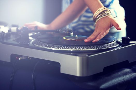 Mixing up the perfect musical offering. Cropped view of a DJ mixing music on a turntable.