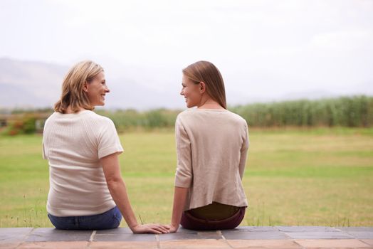 Special mother-daughter moments. A mother and daughter sitting and chatting together in an outdoor setting.