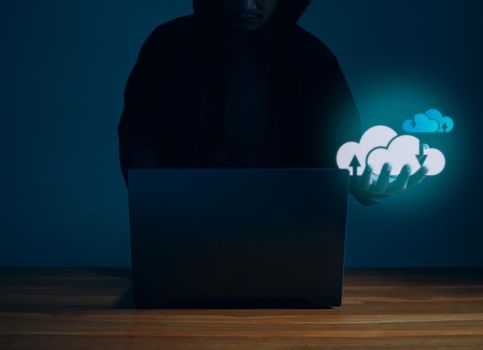 Hackers work on laptops in the dark. Concepts of information security systems in the Internet network and information espionage. Cloud computing.