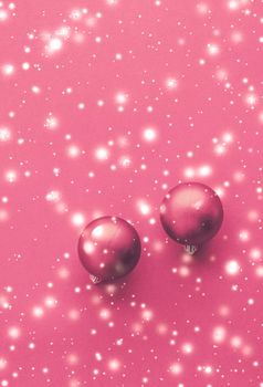 Christmas baubles on pink background with snow glitter, luxury winter holiday card