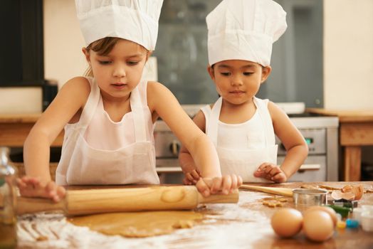 Baking is so much fun. two little girls baking in the kitchen.