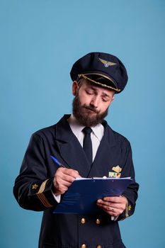 Airplane pilot holding clipboard, filling form