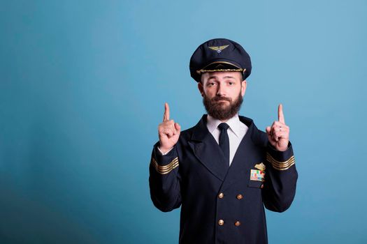 Airplane pilot pointing up with index fingers, advertising product