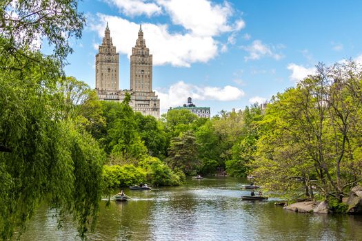 New york, USA - May 15, 2019: Row boats in lake in Central Park with Eldorado building in distance, Manhattan, New York city, USA