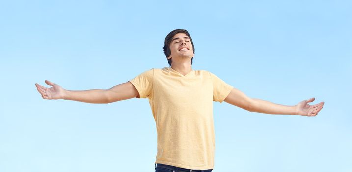 Feel the freedom. A young man standing with his arms outstretched.