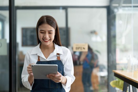 Asian women Barista smiling working small business owner using tablet ordoring food and drink cafe concept