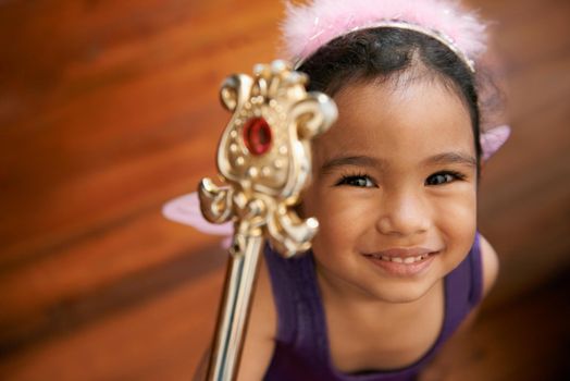Shes the queen of her destiny. A little girl in a fairy outfit smiling while holding her wand.