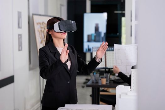 Architect in ar helmet touching virtual building project