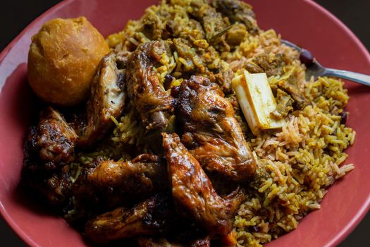 Jamaican jerk chicken wings, curried goat and fried dumpling with rice and peas