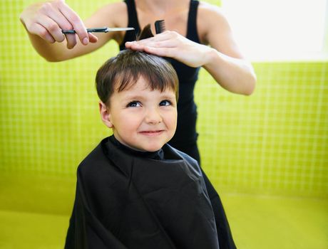 Why do I even need a haircut. a young boy getting his first haircut.