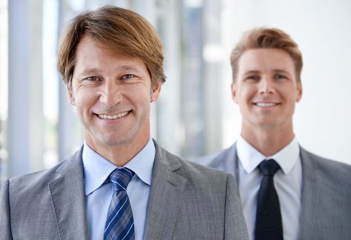 An effective boss is an effective leader. Head and shoulders shot of two successful businessmen wearing suits and looking at the camera.