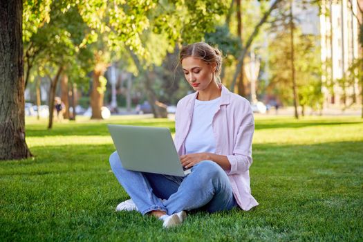 Businesswoman sitting grass summer park using laptop Business persone working remote. Outdoors