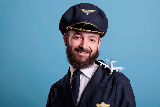 Smiling pilot with airplane model on shoulder portrait