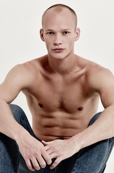 Relaxed in denim. Studio portrait of a bare-chested male model in jeans.