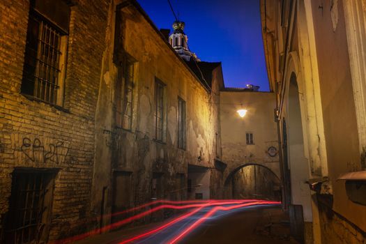 Street and luminous track from the car at night in Vilnius Old Town, Lithuania