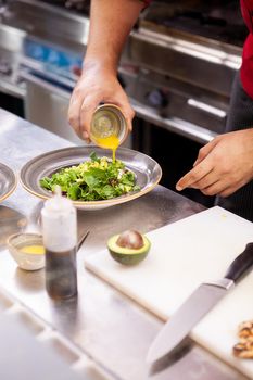 Chef seasoning salade with lemon juice