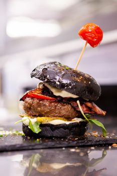 Black burger on stone cutting board
