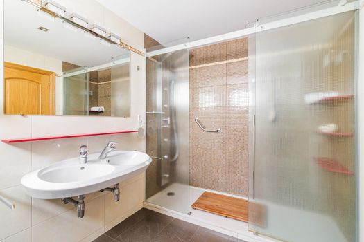 Interior of a bathroom in light tones with spacious shower