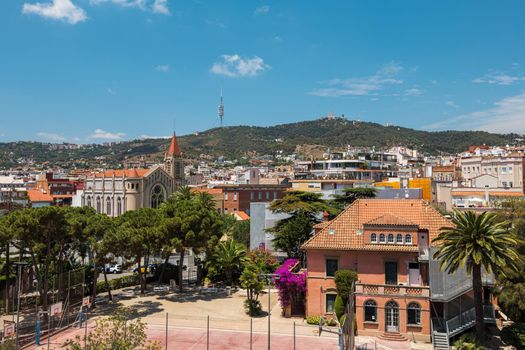 View from a rooftop of typical living area in Barcelona with antenna and mountain at the background
